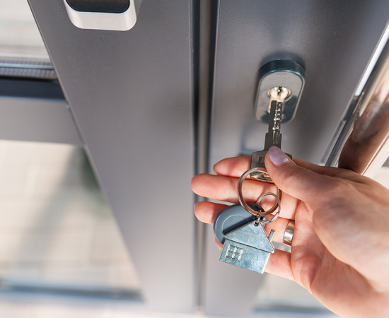 hand putting key in door lock